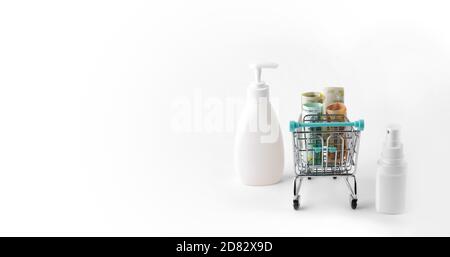 un piccolo carrello pieno di banconote, con bottiglie di disinfettante nelle vicinanze Foto Stock