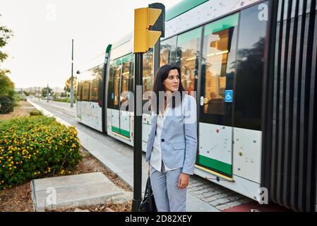 Lavoratore femminile in attesa di trasporto pubblico. Foto Stock