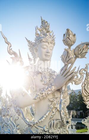 bianco scultpuro di buddha che tiene fiori Foto Stock