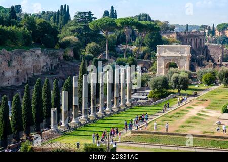 Edifici dell'antica Roma, vista sulle colonne di via Sacra e sull'Arco di Tito con turisti, le rovine del Colle Palatino, Roma, Italia Foto Stock