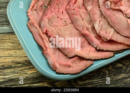 Rare fette di manzo arrosto alla griglia londinese su piatto di portata blu Foto Stock