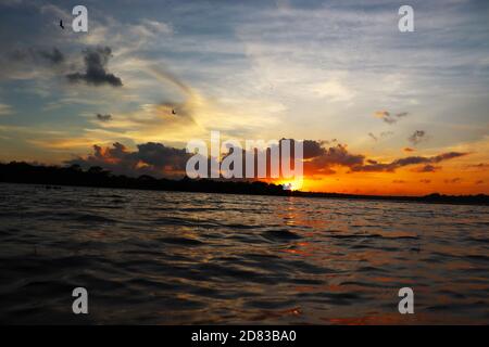 il sole serale che si nasconde all'orizzonte Foto Stock