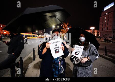 Varsavia, Polonia. 26 ottobre 2020. I manifestanti sono visti in possesso di segni con riferimenti alla serie televisiva distopica "la cameriera" a Varsavia, Polonia, il 26 ottobre 2020. Lunedì, per il quinto giorno consecutivo, i manifestanti pro-scelta sono scesi in piazza per manifestare contro la recente sentenza del Tribunale costituzionale, che ha portato ad un divieto quasi totale degli aborti. Migliaia di manifestanti in tutto il paese hanno risposto a chiamate spontanee per bloccare il traffico. Foto Stock