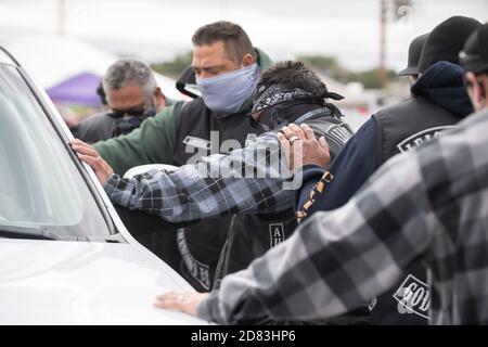 I membri del club motociclistico Christian Least of Saints aspettano di pregare con le famiglie in stile drive-in durante il 15° HopeFest annuale, fatturato come la più grande fiera delle risorse familiari di Austin. L'evento di quest'anno, sponsorizzato da Austin Voices, ha attirato centinaia di famiglie e decine di fornitori in un formato drive-through sicuro. Foto Stock