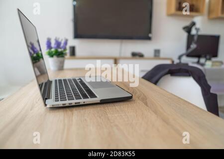 Business Office con computer portatile e fiori su un tavolo di legno. Foto Stock