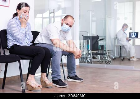 Coppia sconvolta nella sala d'attesa dell'ospedale dopo le cattive notizie da parte di personale medico. Medico che dà risultati di prova sfavorevoli. Ha sottolineato l'uomo e la donna durante l'appuntamento medico. Foto Stock