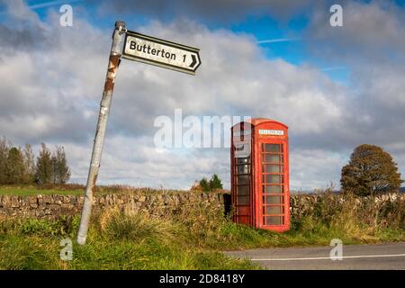 Regno Unito, Inghilterra, Staffordshire, Moorlands, Grindonmoor Gate, segnale di strada pendente per Butterton at Working K6 telefono box Foto Stock