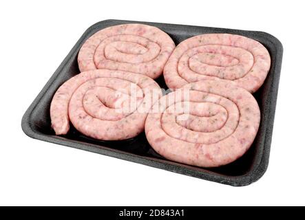Vassoio di quattro rotolini di maiale crudo in Cumberland isolati uno sfondo bianco Foto Stock