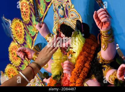 Guwahati, Assam, India. 26 Ottobre 2020. I devoti eseguono rituali prima dell'immersione della dea indù Durga nelle acque del fiume Brahmaputra durante l'ultimo giorno del festival Durga Puja a Guwahati, India, il 26 ottobre 2020. L'ultimo giorno del festival si chiama Vijay Dashmi con Vijaya che significa 'vittoria' e Dashmi che significa 'decimo'. Durga Puja è ampiamente celebrato negli stati indiani del Bengala Occidentale, Assam, Jharkhand, Orissa e Tripura e culmina nella immersione degli idoli della dea indù Durga. Credit: ZUMA Press, Inc./Alamy Live News Foto Stock