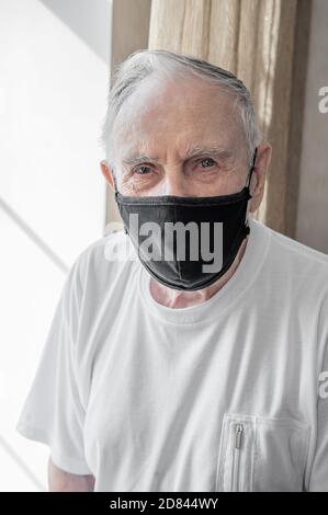 uomo anziano in una maschera medica. Ha l'influenza. Proteggere le persone intorno a voi dal virus. Concetto di pandemia. Primo piano Foto Stock