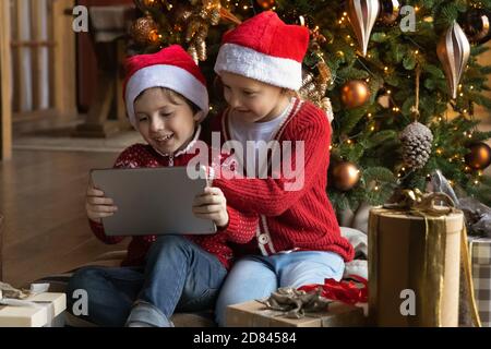 I bambini piccoli felici si divertono a usare il tablet durante le vacanze Foto Stock