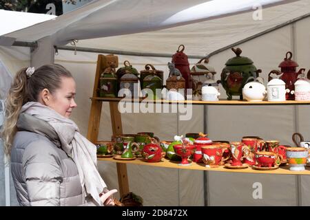 Bella ragazza cercando e vasi in ceramica in una strada tradizionale mercato Foto Stock