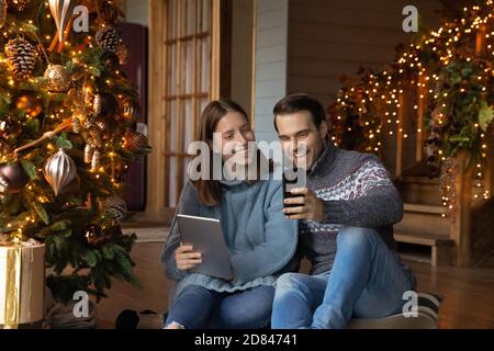 La coppia felice si diverte utilizzando i moderni gadget a casa Foto Stock