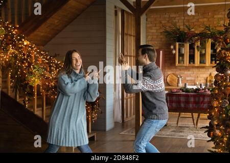 Una coppia molto felice si diverte a festeggiare il Natale a casa Foto Stock
