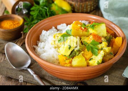 Piatto di cucina indiana sabji. Stufato tradizionale indiano di verdure con formaggio morbido, curcuma e riso su un tavolo di legno. Foto Stock