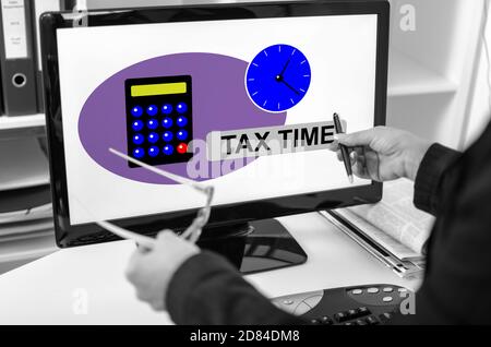 Donna d'affari che mostra il concetto di tempo fiscale su uno schermo del computer Foto Stock