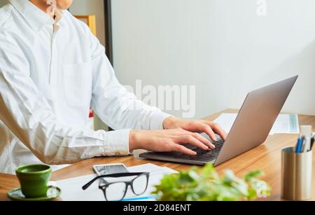 Uomo giapponese che lavora da casa Foto Stock