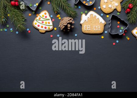 Forme per cucinare e biscotti di natale su sfondo nero con spazio di copia Foto Stock