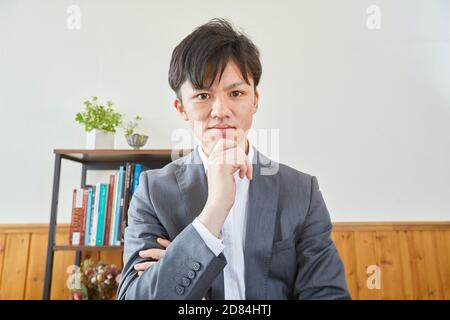 Uomo giapponese che lavora da casa Foto Stock