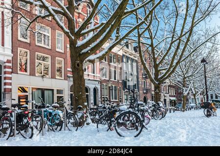 Piazza della città di Amsterdam in inverno con biciclette innevate Foto Stock