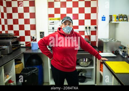 Netherton, West Midlands, Regno Unito. 27 ottobre 2020. Sarah Peniket-Aldridge prepara pasti da asporto nel suo bar - Netherton Cafe - nel Black Country, West Midlands, per i bambini durante il semestre scolastico. "Abbiamo inviato decine di pasti caldi per i bambini affamati. Forniamo anche quelli che isolano da Covid e alcune persone non possono pagare fino a quando non ottengono il loro credito universale o salari. Ma ottengono il loro cibo e li lasciamo pagare quando possono", dice. "Non lascerò che nessuno vada affamato." Netherton, a Sandwell, è in alto allerta, ed è una delle zone più povere dell'Inghilterra. Foto Stock