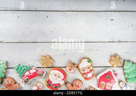 Sfondo natalizio con biscotti fatti in casa con pan di zenzero. Tradizionale cottura invernale festiva, piatto, om bianco sfondo di legno spazio copia. Foto Stock