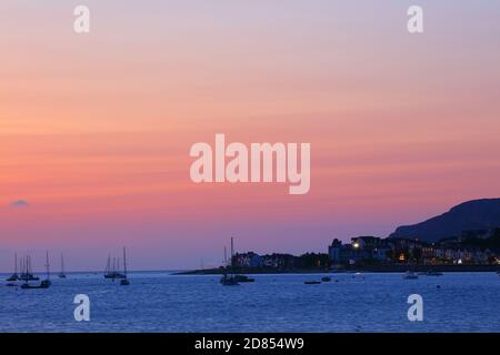 Vista sul fiume Conwy verso l'estuario di Conwy con la città di Deganwy in lontananza a Sunset, Galles del Nord, Regno Unito. Foto Stock