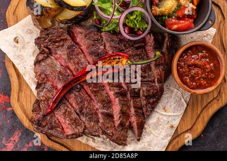 Grigliata mista di carne piatto. Un assortimento di deliziose grigliate di carne con verdure. Grigliata mista di carne con salsa di peperoni e verdure. Foto Stock