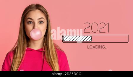 Donna che soffia Bubble-Gum, in attesa 2021 nuovo anno di caricamento processo, sfondo rosa Foto Stock