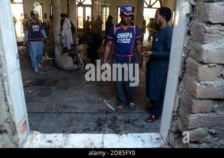 Peshawar, Pakistan. 27 Ott 2020. I soccorritori pakistani e i poliziotti esaminano il sito di un'esplosione di bombe in un seminario islamico a Peshawar, in Pakistan, il 27 ottobre 2020. Una potente bomba scoppiò nel seminario islamico alla periferia della città pakistana nordoccidentale di Peshawar martedì mattina, uccidendo alcuni studenti e ferendone decine altri, ha detto la polizia e un portavoce dell'ospedale. (Foto di Hussain Ali/Pacific Press/Sipa USA) Credit: Sipa USA/Alamy Live News Foto Stock