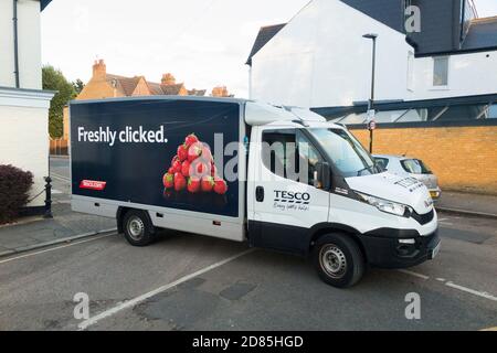 Supermercato Tesco / super market consegna furgone in una strada residenziale o di strada rendendo la consegna a casa e bloccando il bivio e il flusso di traffico. UK (122) Foto Stock