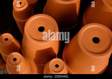 vasi di piante di terracotta arancione in esposizione del centro del giardino, norfolk, inghilterra Foto Stock