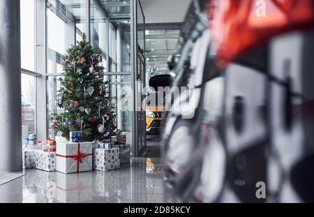 Salone dell'automobile decorato di nuovo anno con l'albero di natale e le automobili Foto Stock