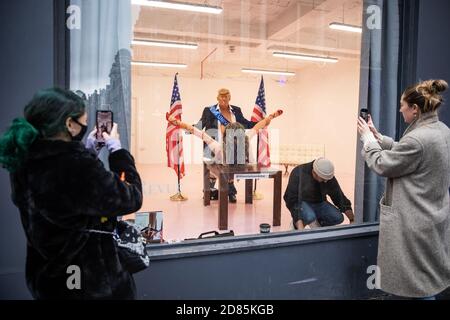 I REDATTORI NOTANO IL CONTENUTO i membri del pubblico fotografano una scultura recentemente installata intitolata "Trump e Miss Universo scultura" dell'artista Alison Jackson, raffigurante il presidente degli Stati Uniti Donald Trump, alla Soho Revue Gallery, Londra. Foto Stock