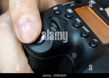 A premendo il pulsante di scatto di una fotocamera digitale, primo piano. A scattare una foto. Foto Stock