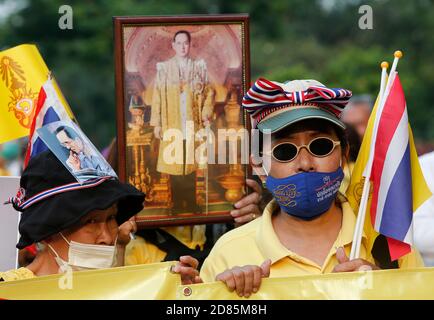 Bangkok, Thailandia. 27 Ott 2020. Un pro-royalist che tiene un ritratto del defunto re della Thailandia Bhumibol Adulyadej al parco Lumpini durante la dimostrazione. Pro-royalists che indossa camicie gialle mentre tiene ritratti della famiglia reale tailandese durante un pro-governo e pro-monarchia rally che chiede la protezione della monarchia al parco Lumpini a Bangkok. Credit: SOPA Images Limited/Alamy Live News Foto Stock