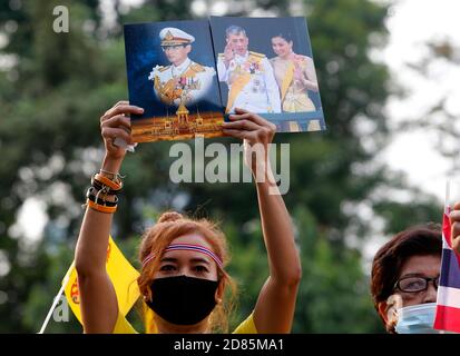 Bangkok, Thailandia. 27 Ott 2020. Un pro-royalist che tiene ritratti al parco Lumpini durante la dimostrazione.Pro-royalists che indossa le camicie gialle mentre tiene i ritratti della famiglia reale thailandese durante un pro governo e un rally pro-monarchico che richiede la protezione della monarchia al parco Lumpini a Bangkok. Credit: SOPA Images Limited/Alamy Live News Foto Stock