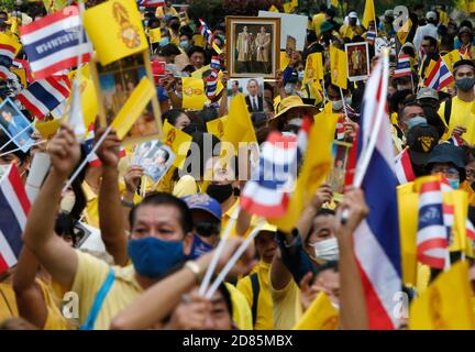 Bangkok, Thailandia. 27 Ott 2020. I pro-royalists tessono bandiere al parco Lumpini durante la dimostrazione.i pro-royalists che indossano le camicie gialle mentre tengono i ritratti della famiglia reale thailandese durante un rally pro-governo e pro-monarchia che richiede la protezione della monarchia al parco Lumpini a Bangkok. Credit: SOPA Images Limited/Alamy Live News Foto Stock