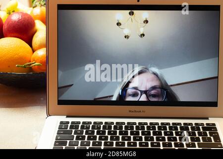 Interazione video giorno moderno. Problema di videoconferenza con zoom in ufficio a casa su MacBook Air con parte superiore della testa sfocata e lampada a sospensione nello scatto. Foto Stock