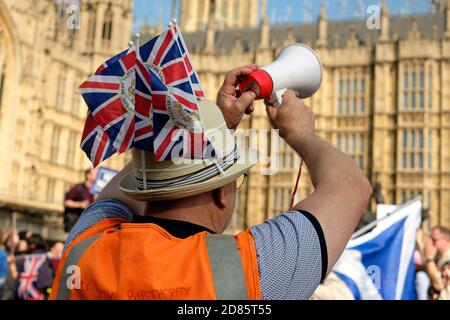 Un palmare megafono / loudhailer e manifestanti durante un Brexit marcia di protesta al di fuori della sede del parlamento di Westminster Londra Gran Bretagna Regno Unito 2019 Foto Stock
