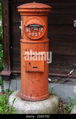 JAPAN, GIU 28 2017, una storica casella di lettere arancione. Il vecchio montante rosso della scatola del montante, Giappone. L'antica cassetta postale rotonda. Foto Stock