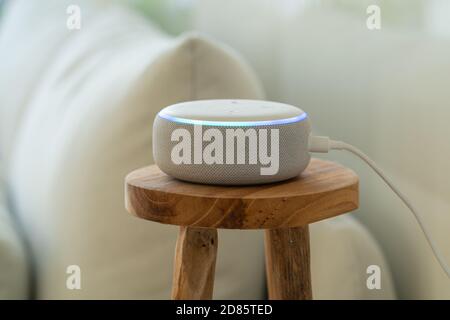 VIENNA, AUSTRIA - Ottobre 26 : un Amazon Alexa Echo bianco su un piccolo tavolo laterale in legno con un divano bianco sullo sfondo Foto Stock