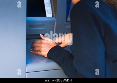 Donna nasconde la tastiera con il numero PIN quando si utilizza una macchina ATM. Proteggi il tuo PIN Foto Stock
