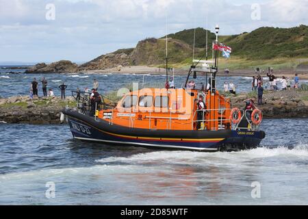 Dunure, South Ayrshire, Scozia , Regno Unito situato sulla costa del Firth di Clyde, ed è vicino a Maybole, a sud di Ayr. In estate si tiene ogni anno un festivale habourside. Una barca di salvataggio RNLI esce dal porto come parte di un'esposizione. Dunure è stato uno dei primi luoghi di ripresa utilizzati per la stagione Outlander 3, essendo stato utilizzato più volte. È stato utilizzato anche nella stagione 4, apparendo nell’episodio 7, ‘Down the Rabbit Hole’. Si trova anche sull'Ayrshire Coastal Path. Foto Stock