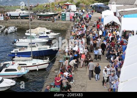 Dunure, South Ayrshire, Scozia , Regno Unito situato sulla costa del Firth di Clyde, ed è vicino a Maybole, a sud di Ayr. In estate si tiene ogni anno un festivale habourside. È stato uno dei primi luoghi di ripresa utilizzati per la stagione Outlander 3, essendo stato utilizzato più volte. È stato utilizzato anche nella stagione 4, apparendo nell’episodio 7, ‘Down the Rabbit Hole’. Si trova anche sull'Ayrshire Coastal Path. Foto Stock