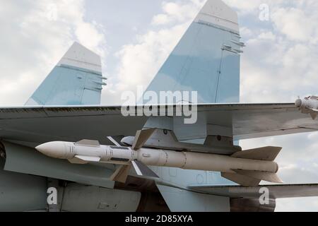 Aereo militare con razzi sullo sfondo del cielo nuvoloso. Foto Stock