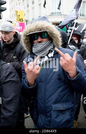 Londra, Regno Unito, 17 marzo 2018:- manifestanti mascherati allo Stand Up to Racism marciano attraverso il centro di Londra Foto Stock