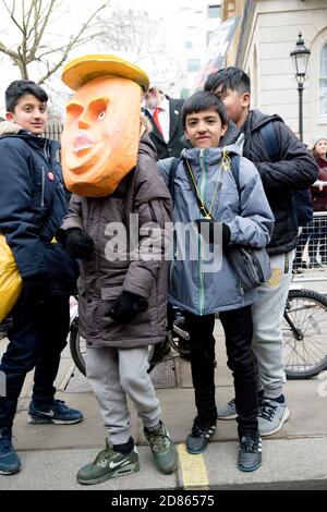 Londra, Regno Unito, 17 marzo 2018:- i bambini provano su una maschera Donald Trump allo Stand Up to Racism marzo attraverso il centro di Londra Foto Stock