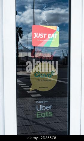 Solo mangiare, Glovo An Uber mangia adesivi sulla porta del ristorante in Spagna Foto Stock