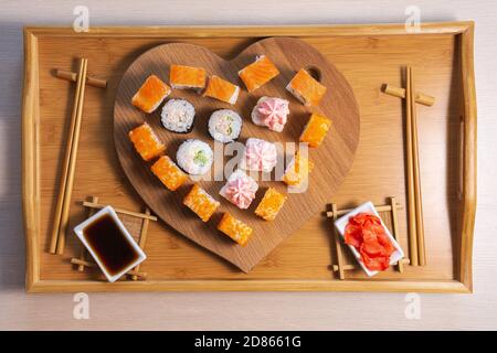 Sushi rotola su sfondo ligneo a forma di cuore. Concetto Febbraio 14, amore San Valentino Foto Stock